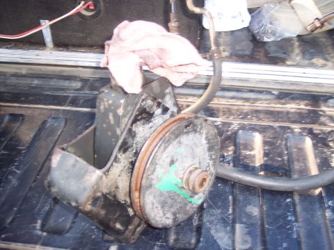 1988 Ford Bronco - Power steering pump removed from a vehicle, shown in a truck bed with a rag.