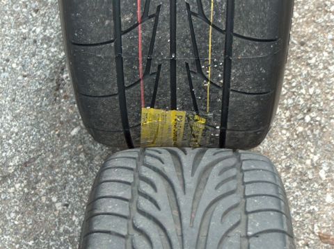 1996 Ford Probe - A close-up view shows two car tires, one larger than the other, resting on a gravel surface.