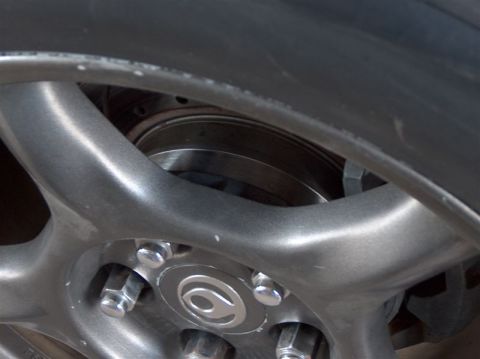 1996 Ford Probe - Close-up view of a car's wheel, showing the brake rotor and lug nuts.