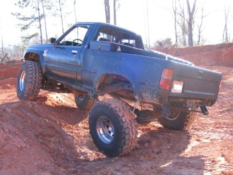 1986 Ford F-150 - This modified Toyota pickup is shown navigating a steep, muddy incline.