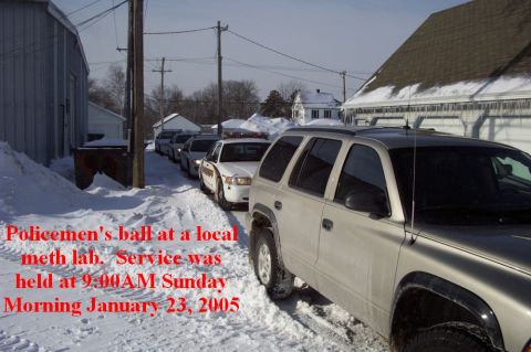 1996 Ford Bronco - A line of police vehicles and a civilian SUV are parked on a snow-covered street.