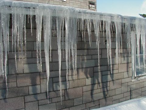 1997 Ford Taurus - Icicles hang from a roof edge above a brick wall on a cold winter day.