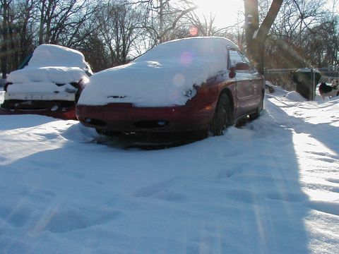 1997 Ford Taurus - Two vehicles are covered in snow on a bright, sunny day.