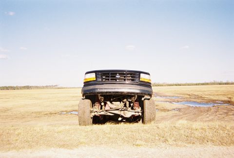 1996 Ford Bronco - Lifted 1997 Ford F-250 front end shown in a dry, grassy field under a clear blue sky.