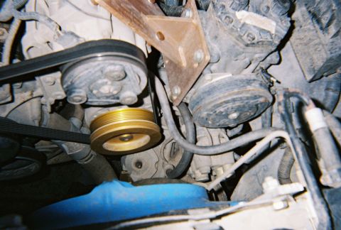 1996 Ford Bronco - Close-up view of engine components, belts and pulleys.