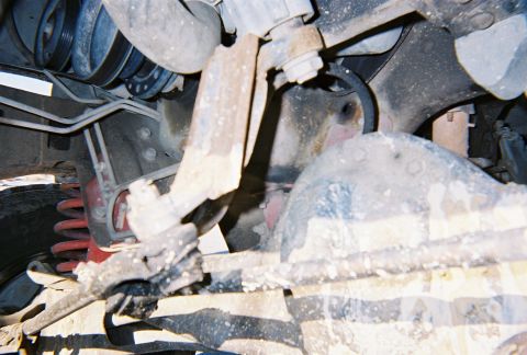 1996 Ford Bronco - Undercarriage view showing suspension and engine parts with visible rust and grime.