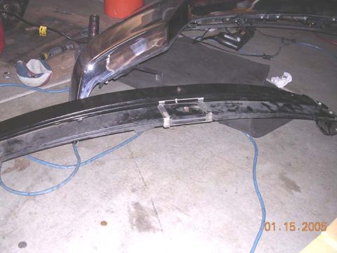 2004 Ford F-250 - Close-up of a chrome bumper and a black trim piece, possibly for a truck, resting on a concrete floor. The image is dated January 15, 2005.