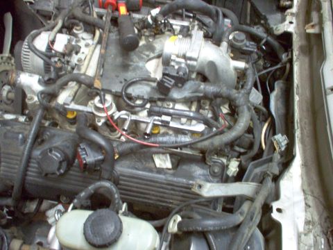 1994 Ford Crown Victoria - The engine bay of a 1994 Ford Crown Victoria is visible, with focus on the fuel system and electrical components.