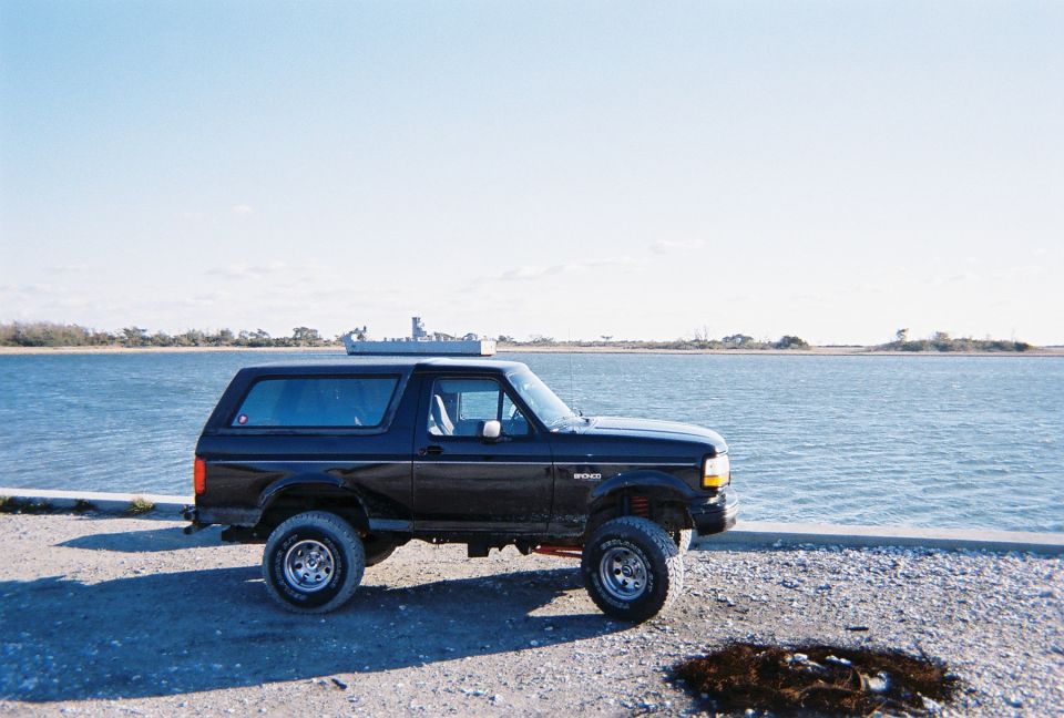 Black Ford Bronco parked by the water