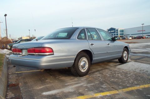 2001 Ford Crown Victoria - A light blue 2001 Ford Crown Victoria is parked in a lot with a Walmart in the background.