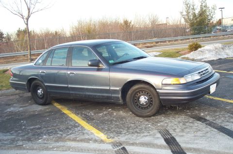 2001 Ford Crown Victoria - Side view of a gray 2001 Ford Crown Victoria in a parking lot.