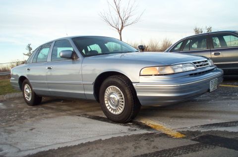 2001 Ford Crown Victoria - This 2001 Ford Crown Victoria is seen from a 3q front angle, with another vehicle parked behind it.