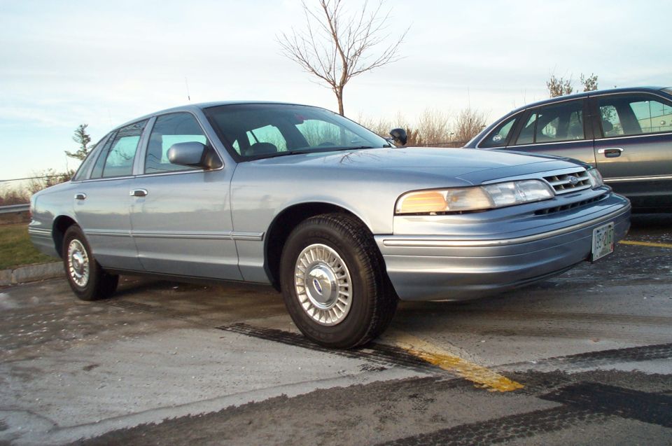 Light blue 2001 Ford Crown Victoria sedan, 3q front view. License plate visible
