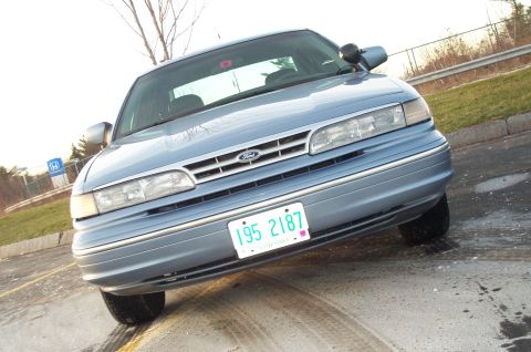 2001 Ford Crown Victoria - A light blue Ford Crown Victoria is parked outside on a cloudy day.
