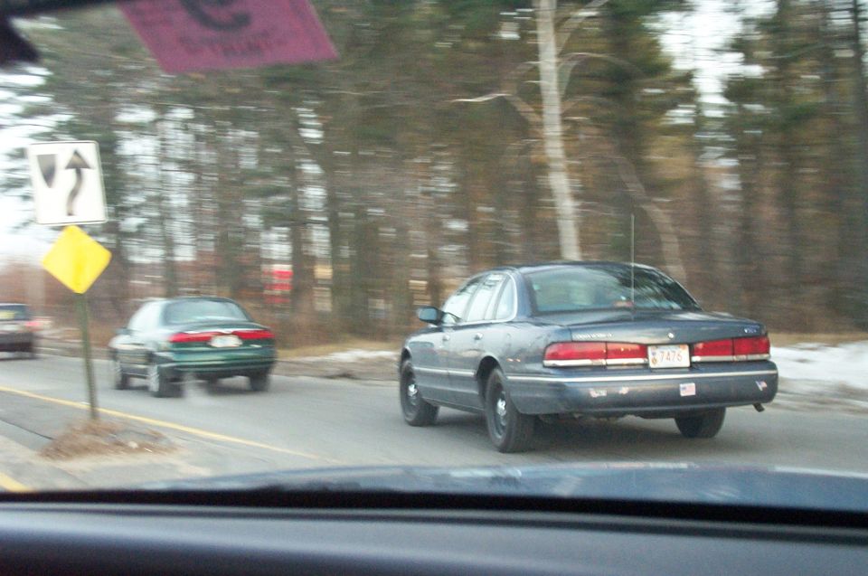 Rear view of a dark blue 2001 Ford Crown Victoria with a license plate reading 7476