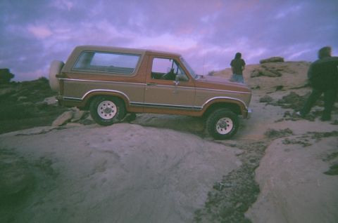 1983 Ford Bronco - This 1983 Ford Bronco is positioned on a rocky landscape with two people nearby.