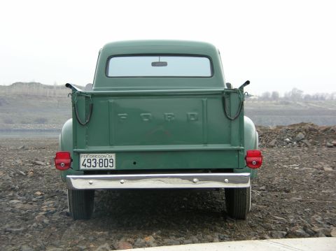1954 Ford F-250 - The rear of a green 1954 Ford F-250 pickup truck is shown, with its distinctive tailgate lettering and Oregon license plate.