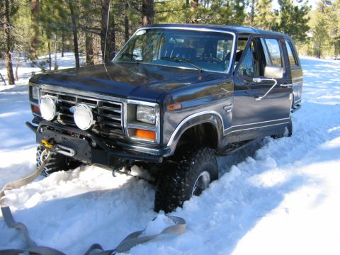 1985 Ford Bronco - This 1985 Ford Bronco is stuck in the snow, equipped with a front winch for recovery.
