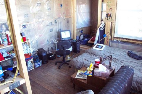 1985 Ford LTD Crown Victoria - This is a scene of a room that appears to be under construction, with a bed, computer, and storage shelves.