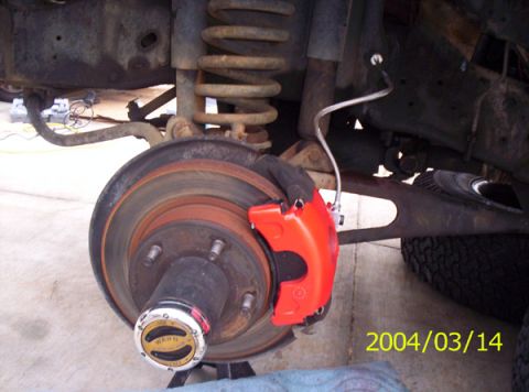 1986 Ford Bronco - The caliper on the rotor, and the braided line connected to the line coming from the MC.I went ahead and put new pads on while I was down t…