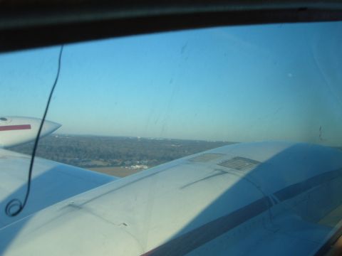 1988 Ford Bronco - Looking out the window of an airplane at the wing and the ground below.