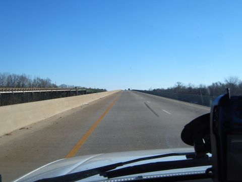 1988 Ford Bronco - View from inside a vehicle driving on a highway under a clear blue sky.