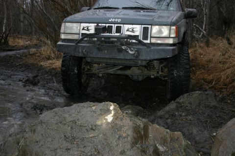 2003 Jeep TJ - This Jeep Grand Cherokee is navigating a muddy and rocky off-road trail.