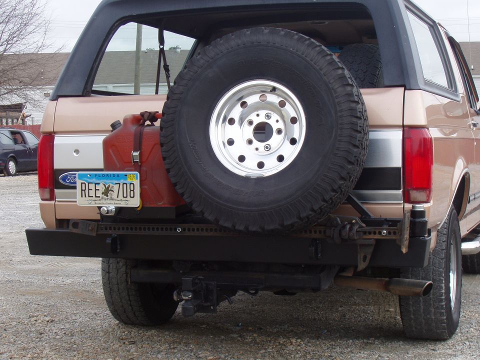 Tan Ford Bronco rear with spare tire, jerrycan, and custom bumper. Florida license plate REE 708