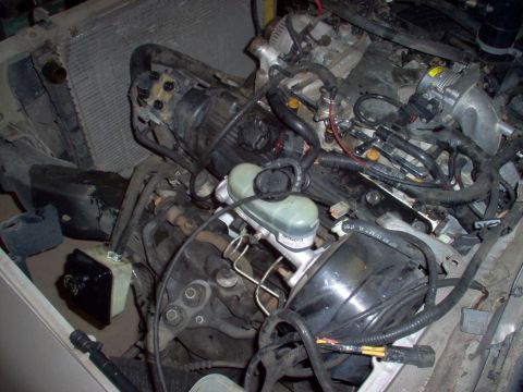 1994 Ford Crown Victoria - Disassembled engine and radiator components, including the brake master cylinder, are shown in this close-up view.