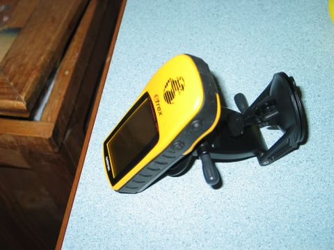 1995 Ford Bronco - A yellow Garmin eTrex GPS unit is shown mounted on a suction cup holder, resting on a blue surface next to a wooden object.