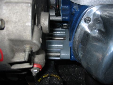 1985 Ford LTD Crown Victoria - Detail of engine parts, including a blue housing and chrome cover, with visible text on a cap.