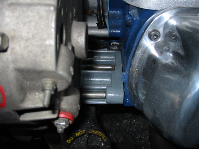 Close-up of engine components with blue housing and chrome cover