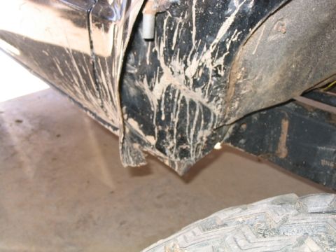 1986 Ford F-150 - Mud covers the fender and frame of a truck, with a tire in the foreground.