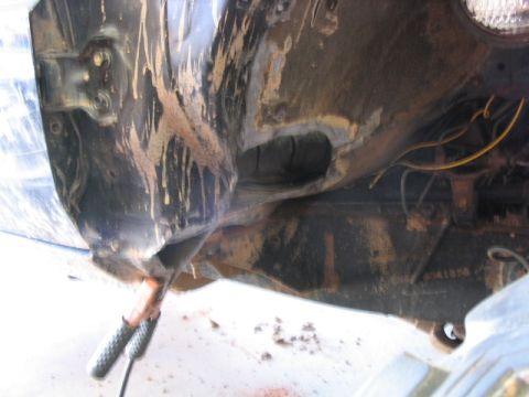 1986 Ford F-150 - Close-up view of heavily soiled vehicle frame and suspension components, showing signs of wear and tear.
