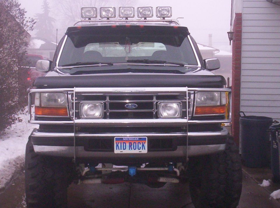 Front view of a black 1993 Ford Bronco with a light bar and brush guard