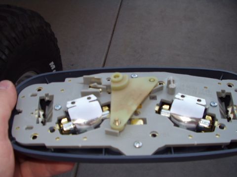 1993 Ford Bronco - The interior dome light assembly shows its internal components, including bulb holders and a rotating mechanism.