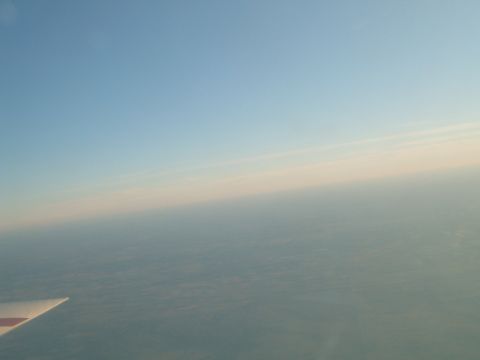1988 Ford Bronco - View from an airplane window showing the wing and clouds below.