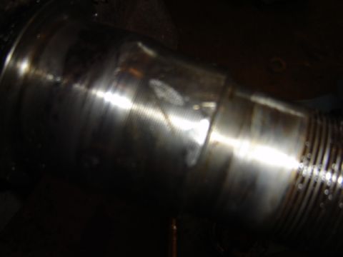 1992 Ford Bronco - This image shows a close-up of a metal component with a ribbed section and a smooth, reflective surface.