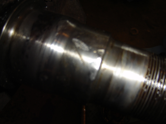 Close-up of a ribbed metal pipe, possibly exhaust or drive shaft