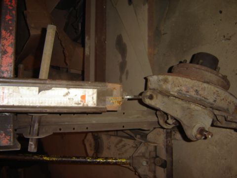 1992 Ford Bronco - A close-up view of a vehicle's suspension part, showing rust and a partial label on a metal bar.