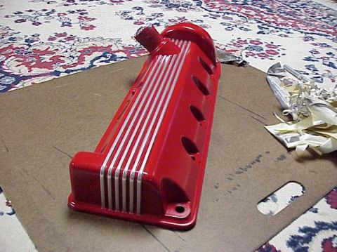 2002 Ford Mustang - Red engine valve cover with silver stripes is shown on a surface with a patterned rug.