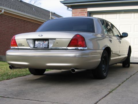 2000 Ford Crown Victoria - Rear view of a gold 2000 Ford Crown Victoria, showing its taillights and dual exhaust pipes.