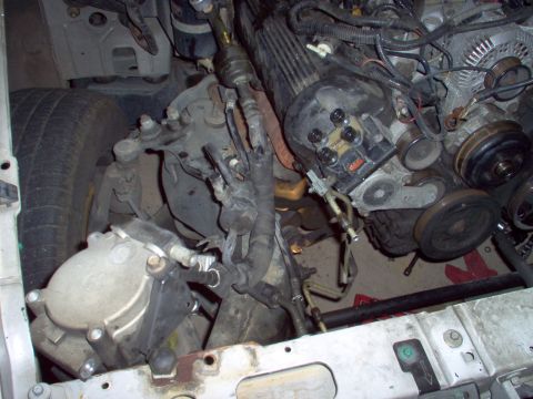 1994 Ford Crown Victoria - Close-up view of engine and suspension components, likely from a vehicle undergoing repair or dismantling.