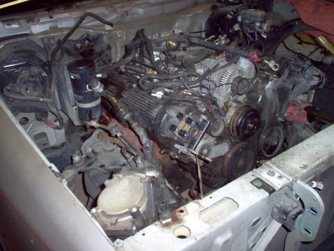 1994 Ford Crown Victoria - The engine bay is shown with the engine partially removed, revealing various components and wiring harnesses.