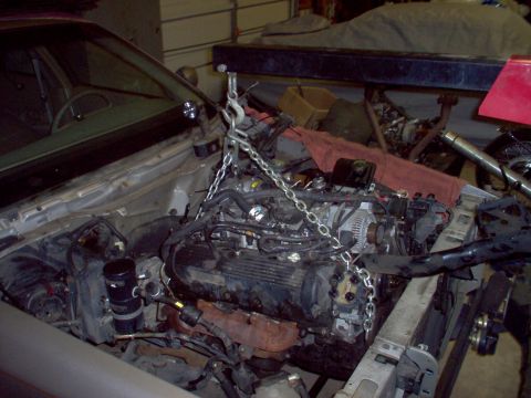 1994 Ford Crown Victoria - The engine is suspended by chains, ready for removal or installation.