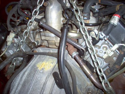 1994 Ford Crown Victoria - Engine components are visible, secured by chains for removal or installation.