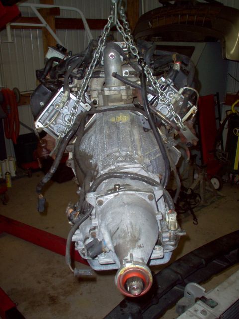 1994 Ford Crown Victoria - Engine and transmission assembly suspended by chains, ready for installation or removal.