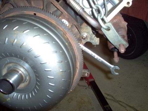 1994 Ford Crown Victoria - Torque converter and engine block detail with a wrench engaged on the flywheel.