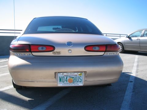 1997 Mercury Sable - The rear of a gold 1997 Mercury Sable LS sedan is shown, parked next to another vehicle.
