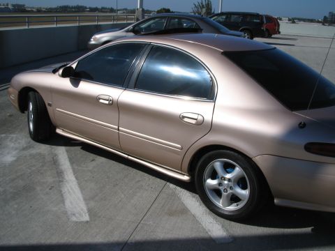 1997 Mercury Sable - Side view of a tan 1997 Mercury Sable sedan parked in a lot.